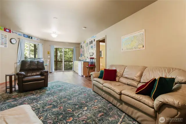Spacious lower-level bonus room features its own sliding glass door, providing natural light and exterior access.