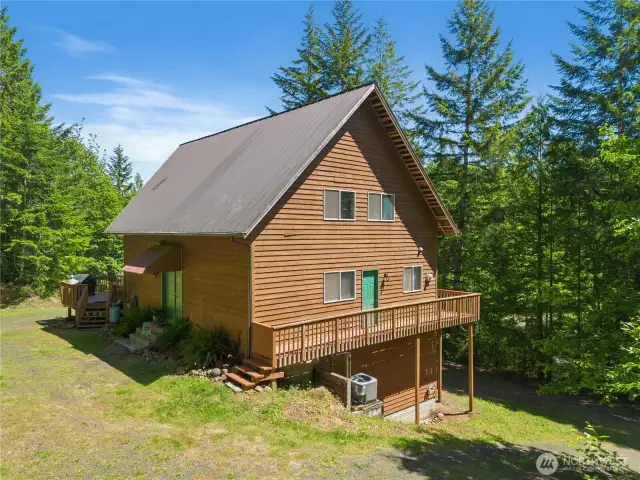 Wrap-around deck spans three sides of the home, allowing easy access between outdoor areas.