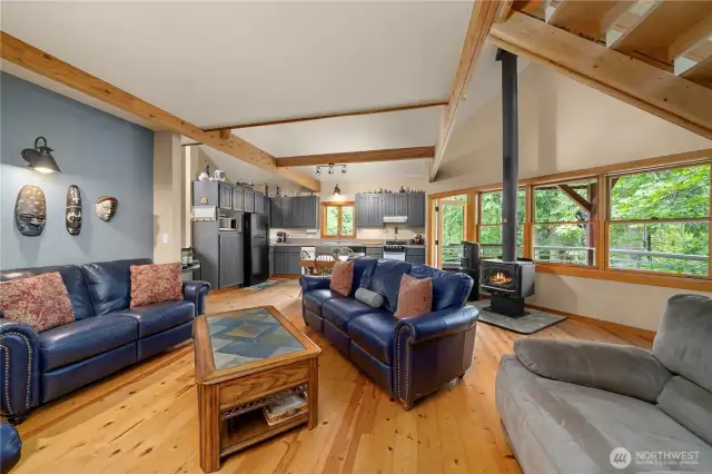 Living room view with large windows allowing nature to shine through