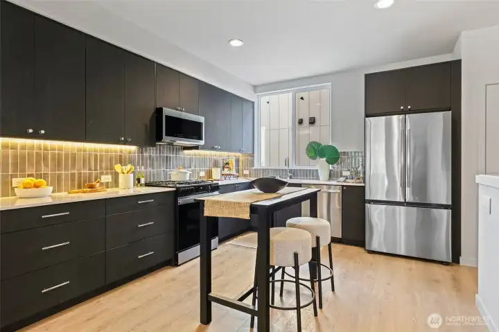 Modern meets timeless in this chef’s kitchen with full-height tile backsplash, stainless steel appliances, and custom cabinetry that pops.