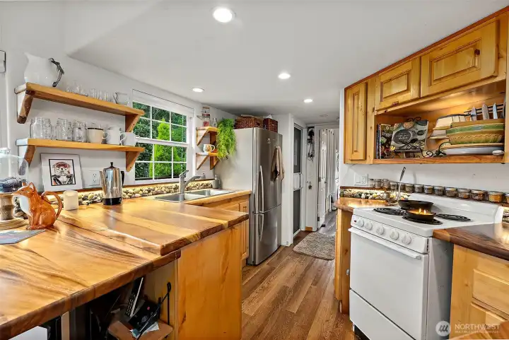 Well-designed kitchen with wood cabinetry and large windows that bring in abundant natural light.