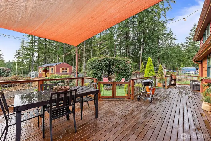 Deck with cover overlooking the peaceful grounds, offering a spacious outdoor setting ideal for dining, relaxing, and enjoying the surrounding landscape.