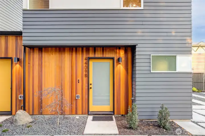 Vertical cedar siding defines the exterior with warmth and texture, setting the architectural tone.