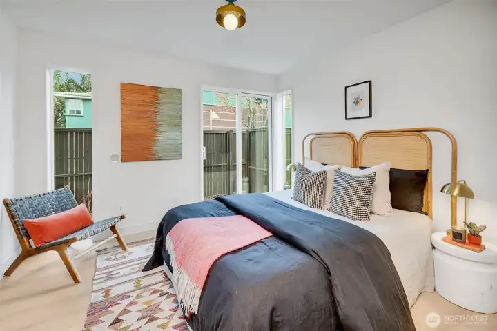 Entry-level guest suite features a large glass slider to a private patio, offering flexible work-from-home potential. A full-tiled bath with a deep soaking tub serves this level.