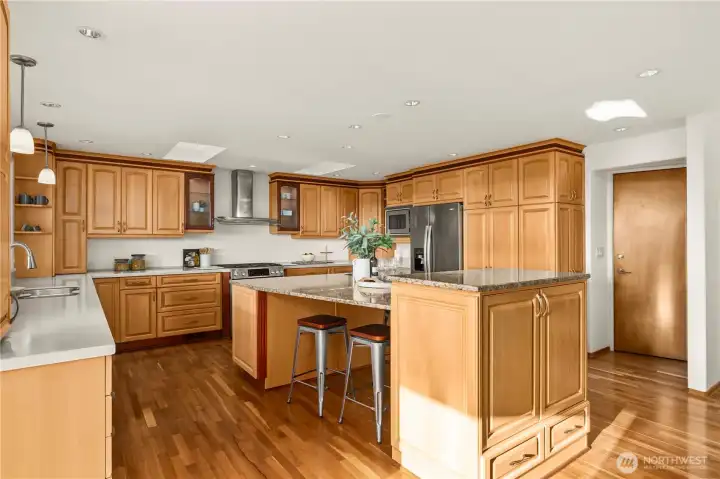 An oversized, light-filled kitchen with expansive windows framing beautiful views