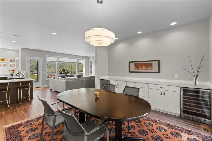 Open dining room to kitchen, living room, and patio with built-in serving drawers and 2 fridges