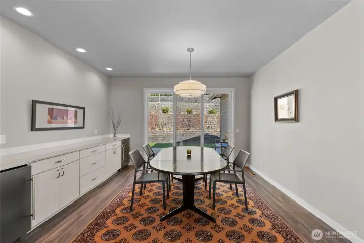 Dining room facing patio door with built cabinets for buffet, beverage + other fridge