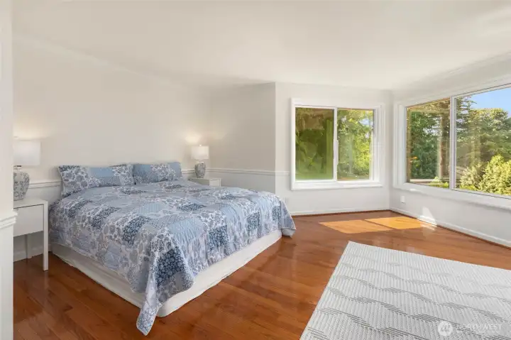 Oversized primary suite with beautiful views of the lush greenery and backyard.