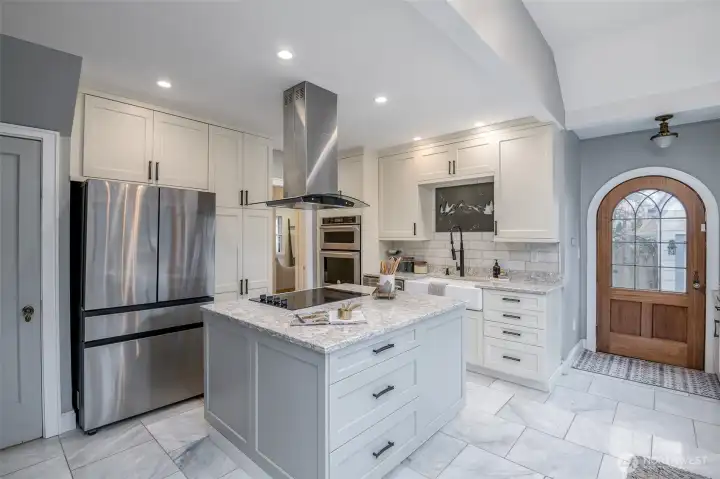 The rounded Hobbit door and screen door are warm and inviting. The door by the refrigerator leads you to the basement staircase.