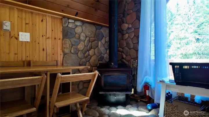 Wood burning stove set against a stone accent wall.