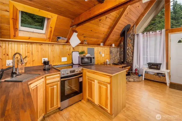 Kitchen remodeled with new fridge, stove, sink, dishwasher, cabinetry, and counters.