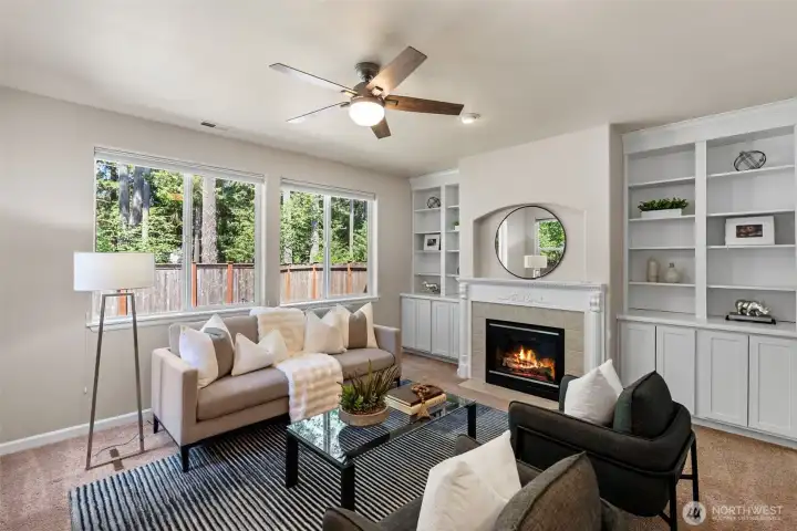 Second living space with  abundant natural light, built-ins, ceiling fan and a gas fireplace.