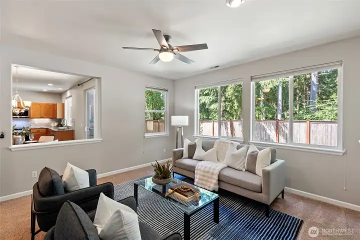 Second living space with abundant light and ceiling fan.