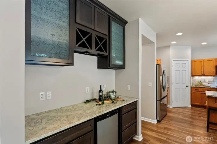 Coffee bar with granite countertops and a beverage fridge.