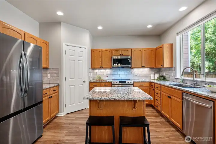 Beautiful kitchen with updated granite countertops, newer, smart stainless steel appliances (2024) and a spacious pantry.