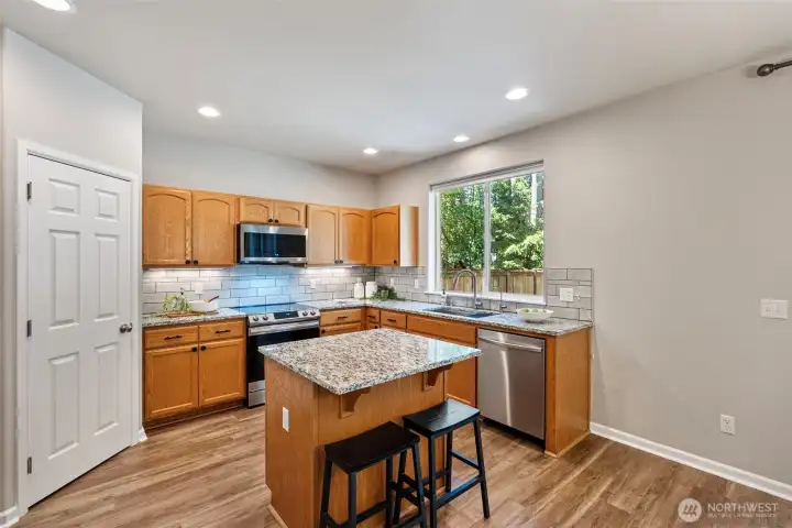 Beautiful kitchen with updated granite countertops, newer, smart, stainless steel appliances (2024) and a spacious pantry.