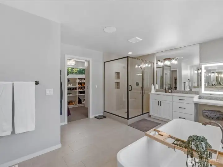 Luxurious primary bath featuring spa-inspired finishes, generous space, and a custom makeup vanity Luxurious primary bath featuring spa-inspired finishes, generous space, and a custom makeup vanity