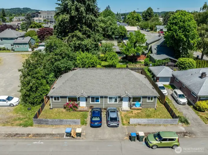 Duplex exterior showcasing private entrances, off-street parking, and fenced outdoor areas.