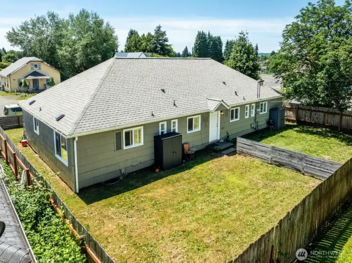 Rear exterior view showcasing the fenced yard and outdoor space associated with the unit.