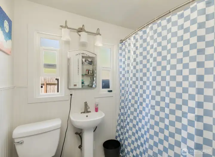 Bathroom includes a shower-tub combination and natural light for added comfort and convenience.