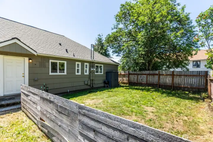 Fully fenced yard provides flexibility for outdoor living and recreation.