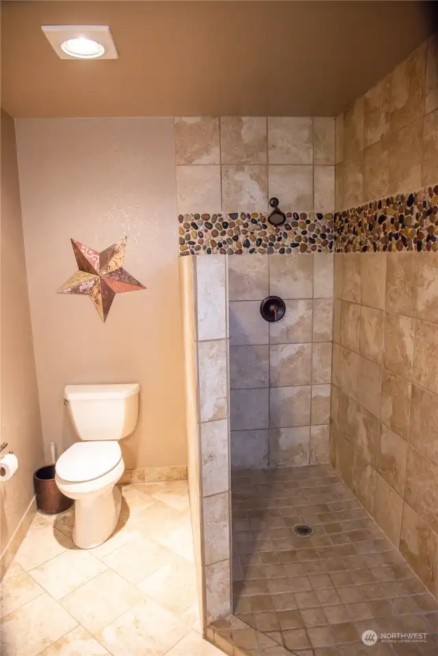 Custom river rock tile inlay primary bathroom shower.