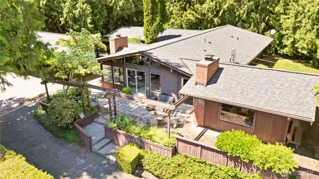 Tucked into 2.68 lush acres, this mid-century gem is wrapped in mature rhododendrons for complete privacy.