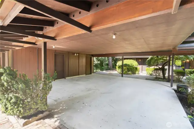 Oversized two-car carport with 2 attached shops room for vehicles, gear, or covered workspace.