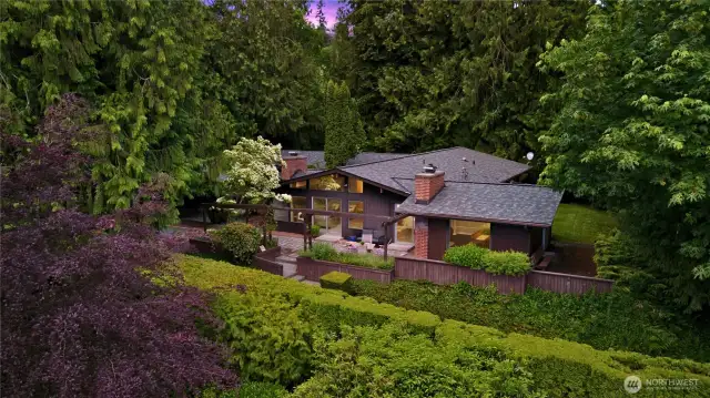 Abundant plantings and mature trees create a lush, curated landscape.