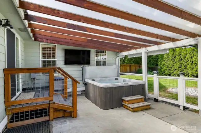 back patio, perfect for entertaining and BBQ cooking, hanging out in theGorgeous covered  big jacuzzi and watching the game on the exterior mounted tv. Also custom fencing for kis playing or pets