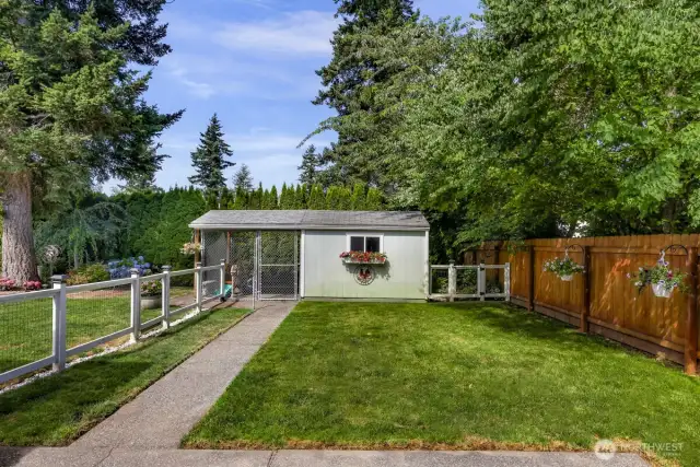 Custom Fenced back yard with two outbuildings