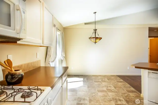 Standing in front of the gas range you can see the very cool chandalier poised over the dining area.