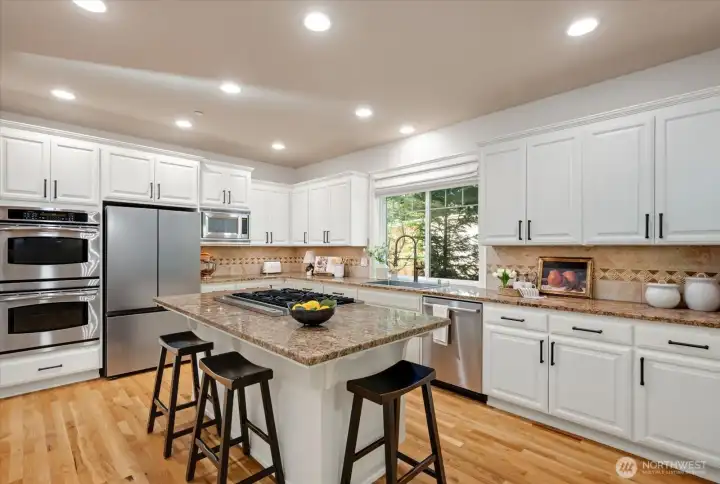 A Chef’s Kitchen: Large kitchen island, granite countertops and updated cabinetry.