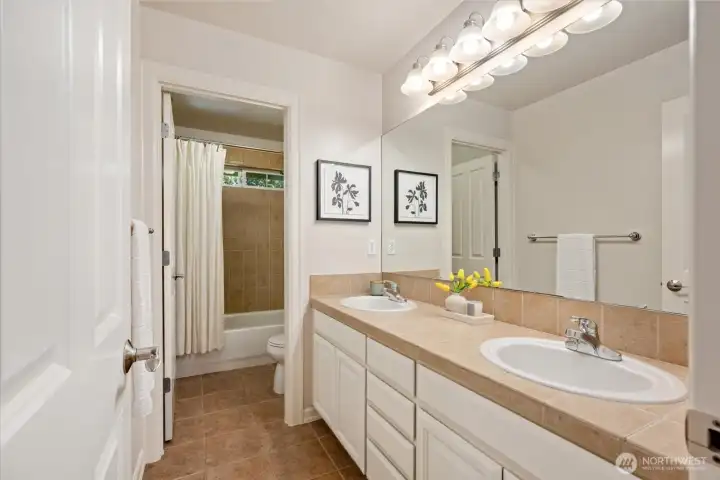 Large guest bathroom with dual vanities, ample storage!