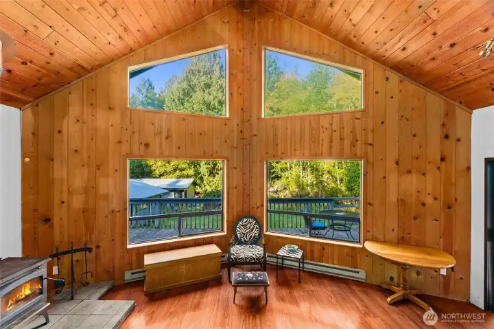 Knotty pine walls and ceilings with large floor to ceiling windows to bring in the nature that surrounds the home