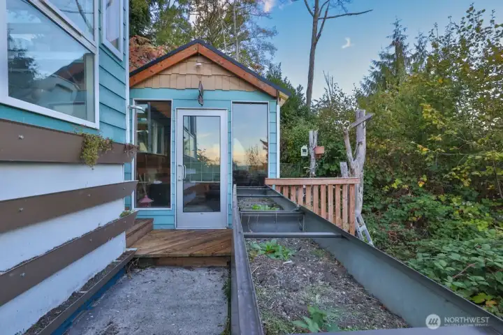 Raised flowers beds along side the shed and greenhouse.