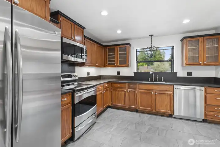 Corner view of the kitchen highlights display-ready mahogany cabinetry and ample counter space for all your prep needs.