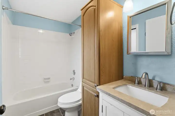 Ensuite bathroom off the primary bedroom featuring a quartz countertop, sink and built-in closet.
