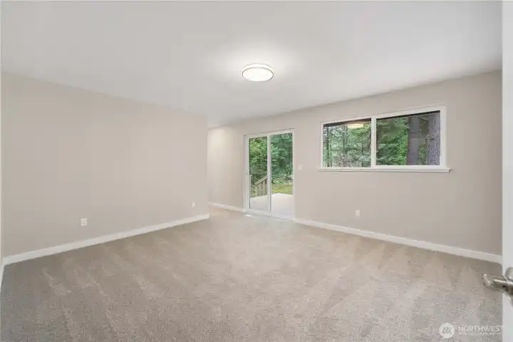 Primary suite offers a large bedroom with large window and slider to a private deck.