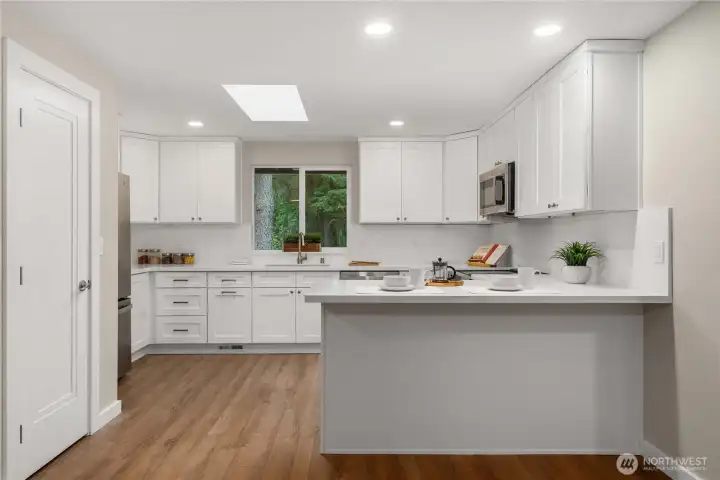 Brand New kitchen offers shaker cabinets, Quartz counters, pantry, skylight, and a window overlooking the backyard.