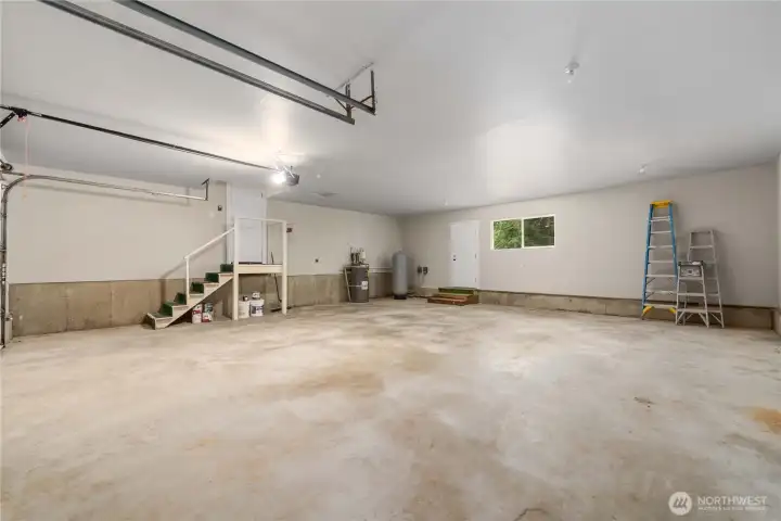 3-car garage has 960 square feet. The door by the window opens to the back of the home and the door at the top of the stairs on the left, enters the home into a hallway near the secondary bedrooms and full bathroom.