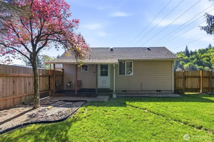 Front view of the home surrounded by a tall privacy fence