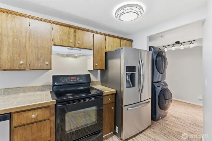 Kitchen facing hallway that leads to a full bath and bedrooms