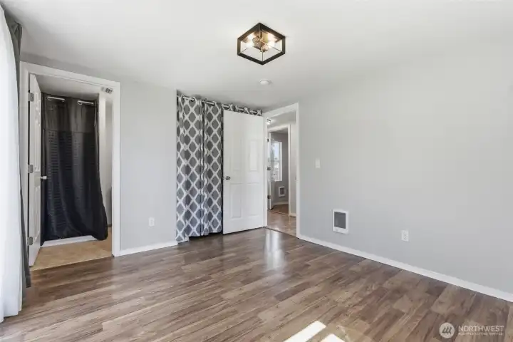 Primary bedroom facing closet and en suite bathroom
