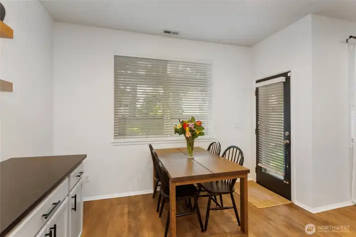 Light-filled dining area with outdoor access featuring a door that opens directly to a covered patio and private backyard—perfect for indoor-outdoor living. The generous space comfortably accommodates a large dining table, while natural light and easy backyard access make it ideal for entertaining, alfresco meals, or everyday enjoyment.