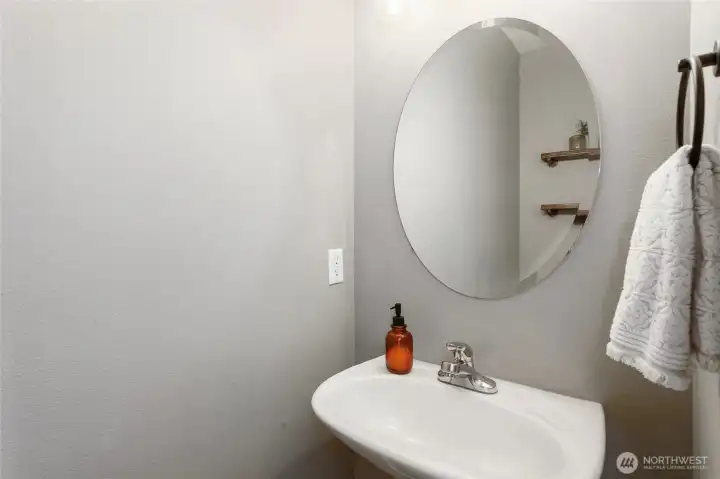 Private main-level powder room thoughtfully tucked away from high-traffic living areas for added privacy and convenience. This well-placed half bath offers easy access for guests while maintaining a quiet, discreet location off the main floor—ideal for everyday use and entertaining alike.