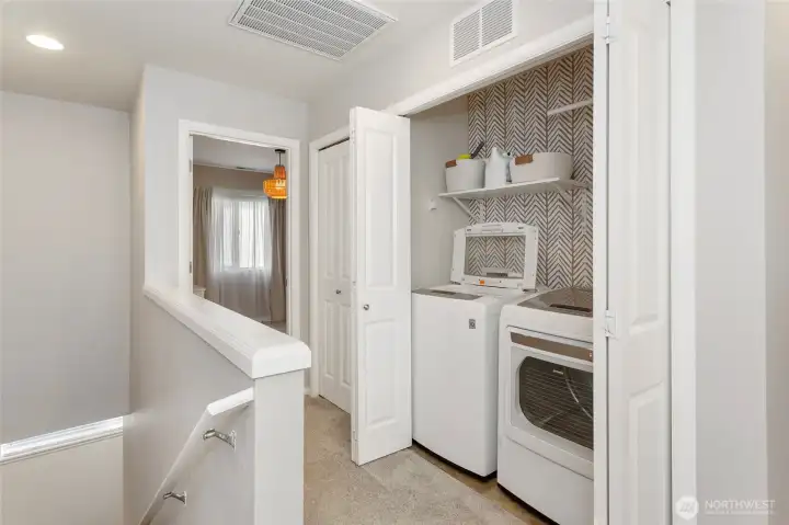 Convenient upstairs laundry area ideally located on the second floor near the bedrooms for easy everyday use. The washer and dryer are thoughtfully tucked into a dedicated laundry closet and are included with the home, adding immediate value and convenience. Open shelving provides extra storage, making this a functional and efficient laundry setup.