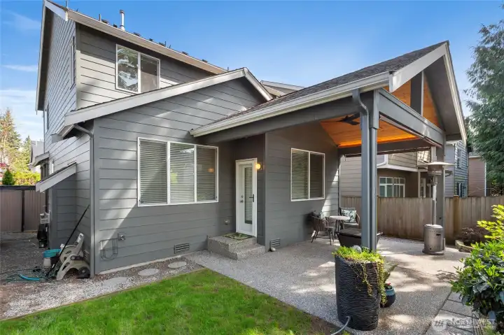 Private, fully fenced backyard featuring a covered patio that extends your living space outdoors. Low-maintenance landscaping and mature greenery create a peaceful setting ideal for relaxing or entertaining.