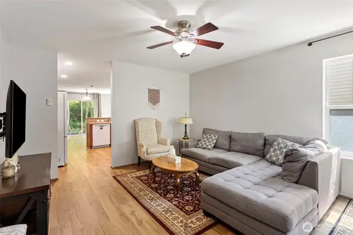 Spacious light living room with ceiling fan for year-round comfort.