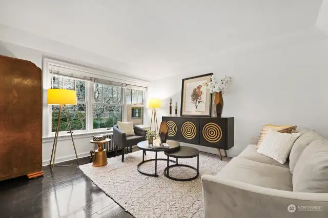 The perfect seating space for conversation and a view of the tree-lined street from the living area. Note the radiator heat, clean, quiet and included in the HOA dues.